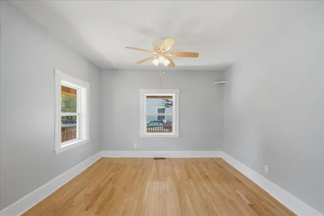 an empty room with a window and wooden floor