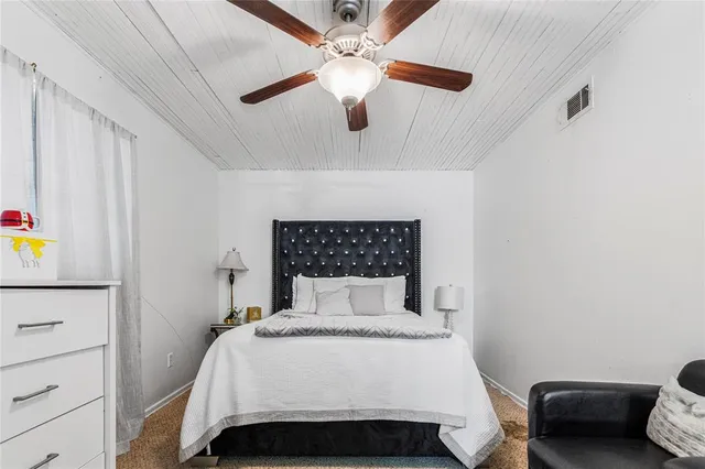a bedroom with a bed and a ceiling fan