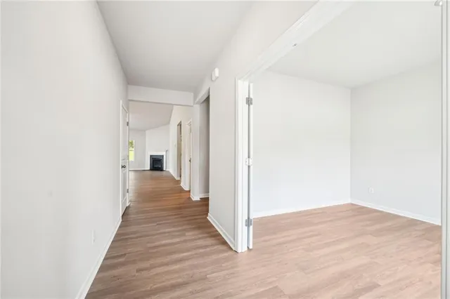 a view of a hallway with wooden floor and staircase