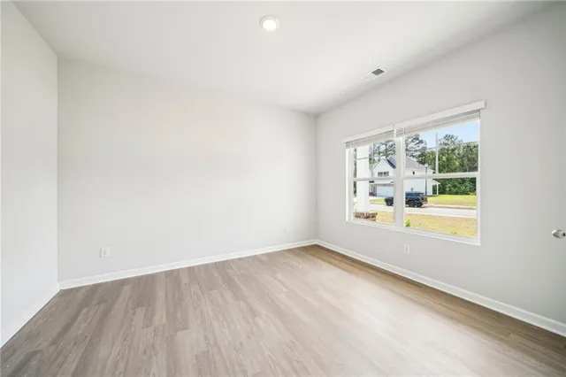 an empty room with wooden floor and window