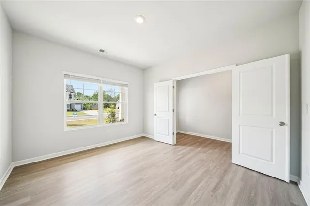 an empty room with windows and fan