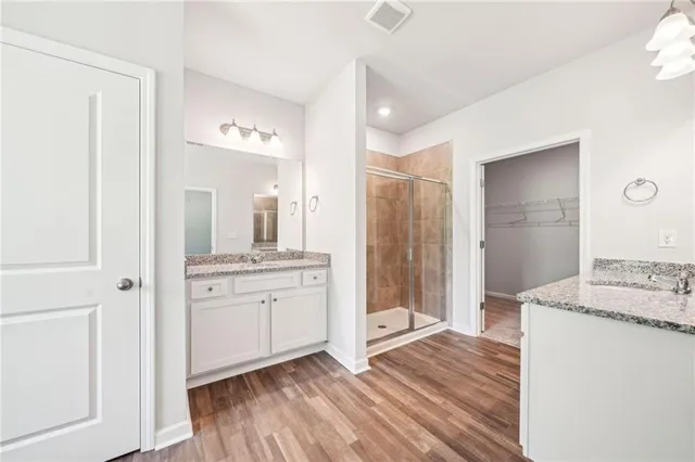 a bathroom with a granite countertop sink a mirror a bathtub and shower