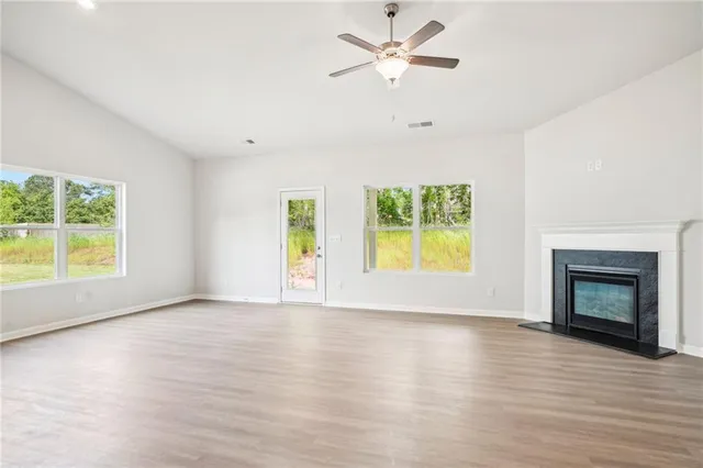 a view of an empty room with a window and fireplace