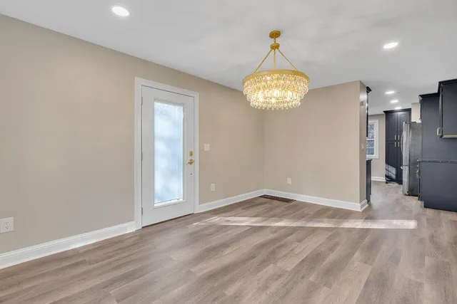 wooden floor in an empty room with a chandelier