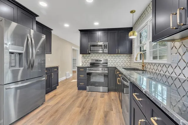 a kitchen with granite countertop stainless steel appliances and wooden cabinets