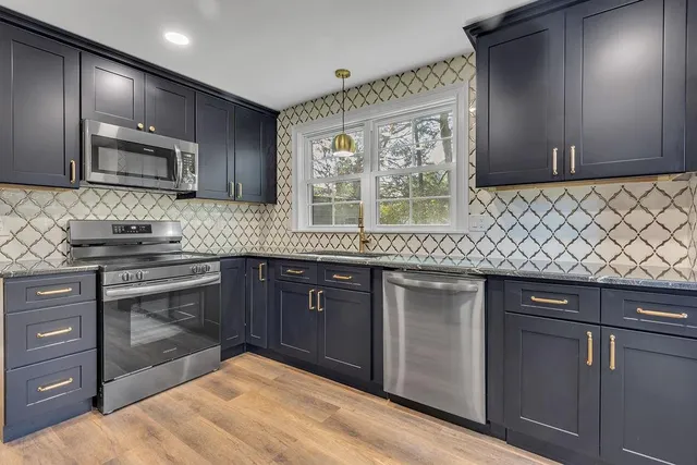 a kitchen with stainless steel appliances granite countertop a sink stove and cabinets