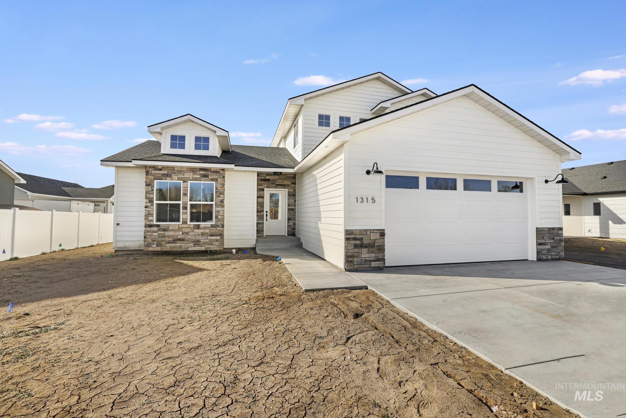 View of front of house with stone siding, driveway, roof with shingles, and a garage