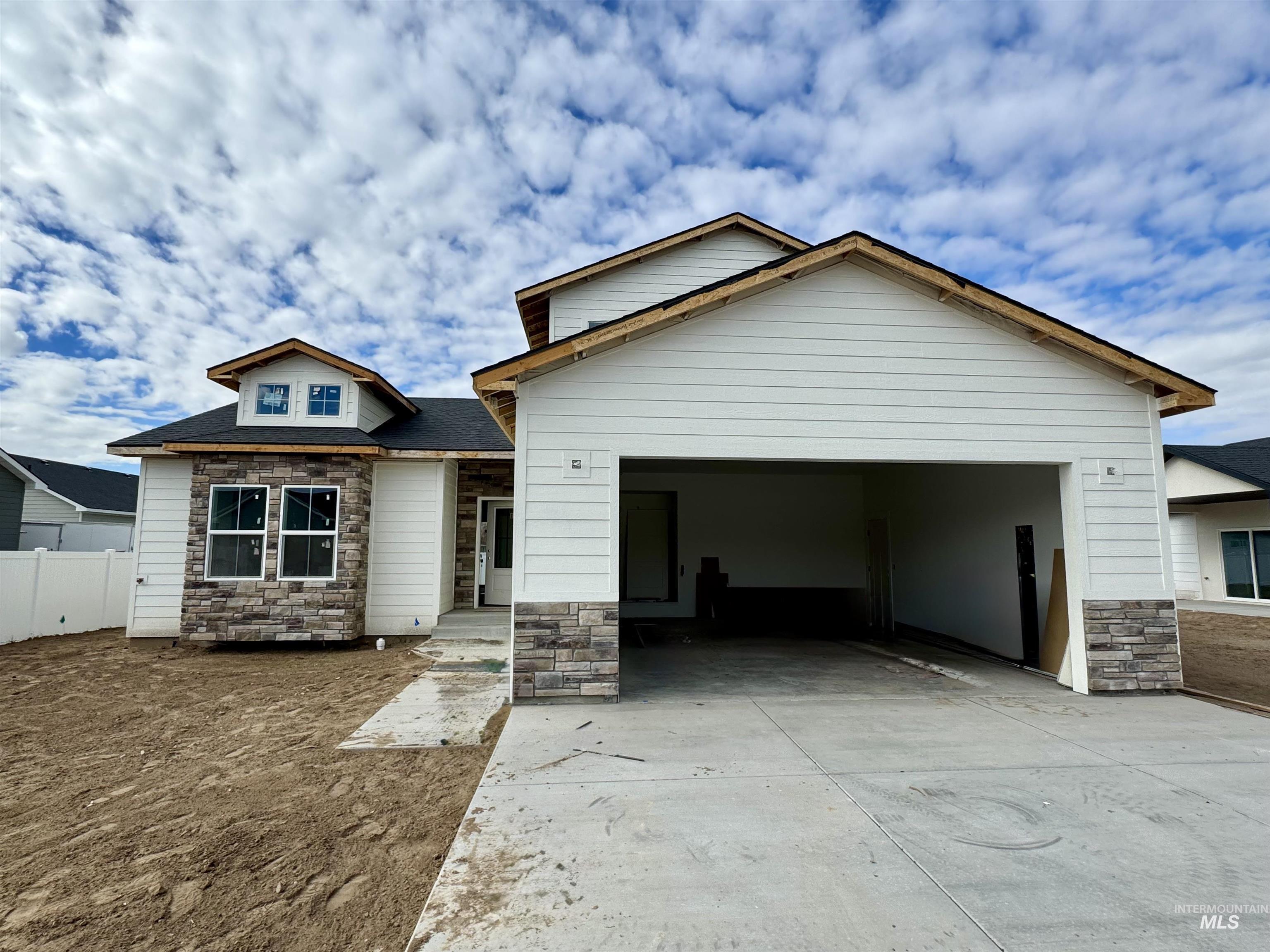 View of front of house with stone siding, concrete driveway, and a garage