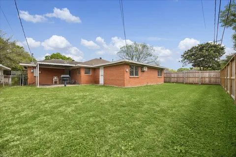 a front view of house with yard and trees in the background