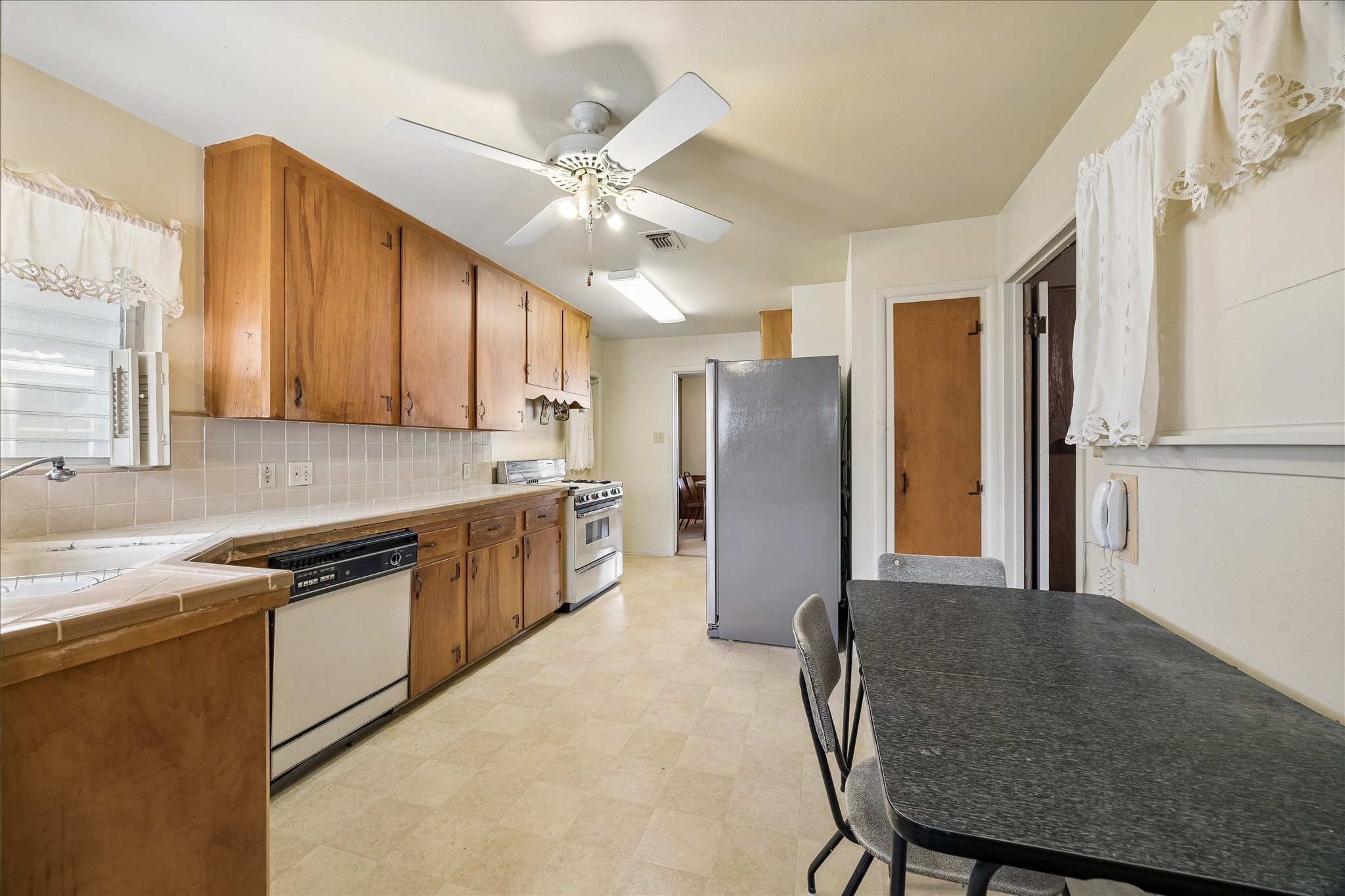 6131 Birdwood Road Houston, TX 77074 - Photo 5 of 14 a kitchen with stainless steel appliances granite countertop a refrigerator a sink a stove and island