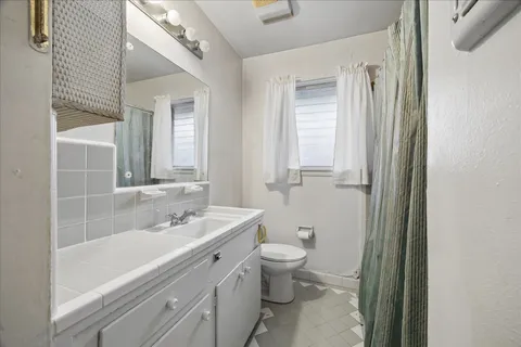 a bathroom with a sink a toilet and a mirror