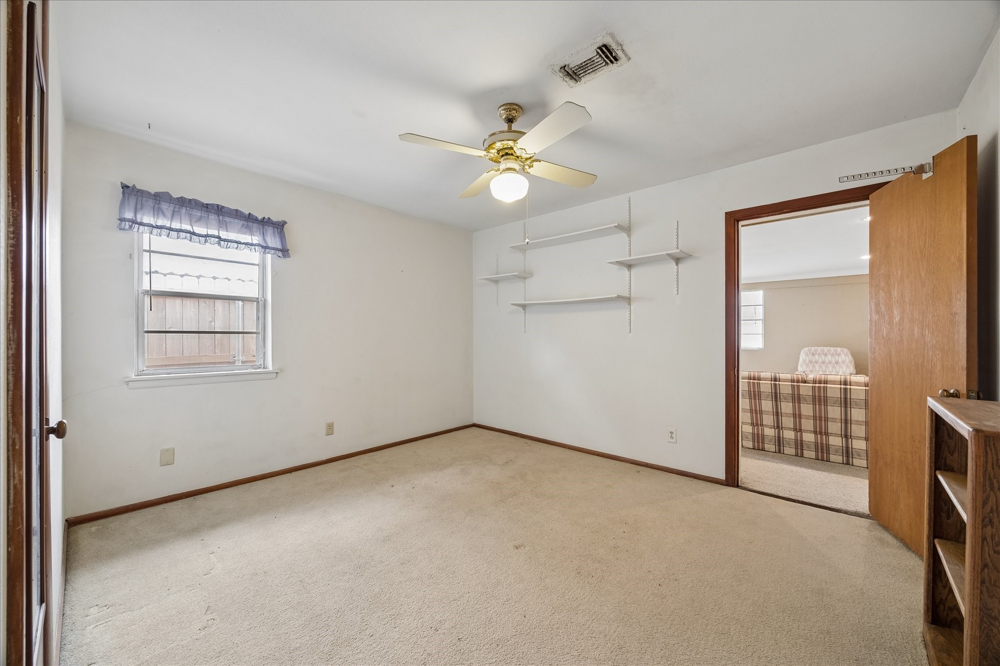 6131 Birdwood Road Houston, TX 77074 - Photo 10 of 14 an empty room with chandelier fan and windows