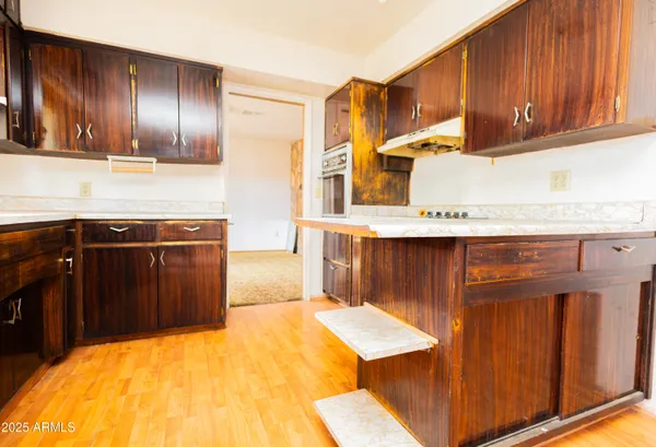 a kitchen with stainless steel appliances wooden cabinets and a counter top space