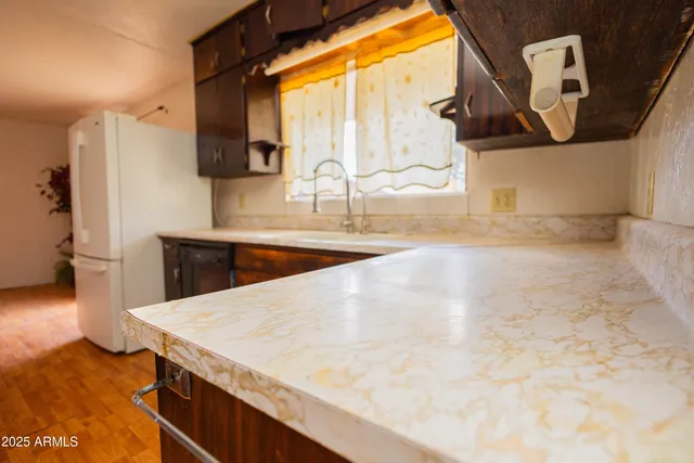 a kitchen with a sink a stove and a wooden floor