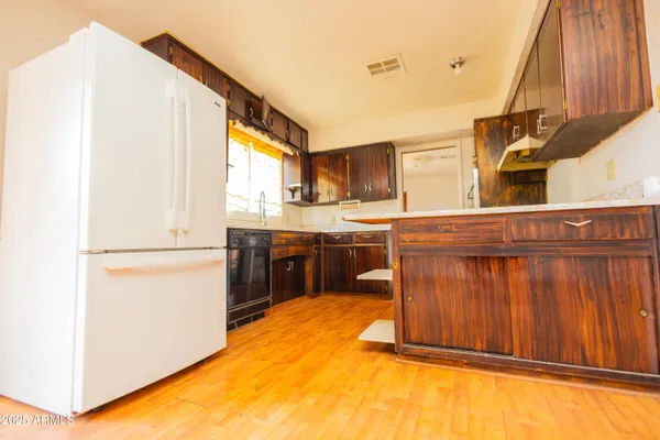 a kitchen with kitchen island a stove a sink and a refrigerator with wooden floor