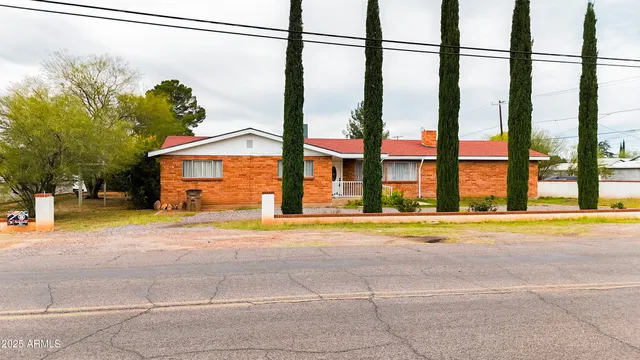 a view of an house with backyard and road