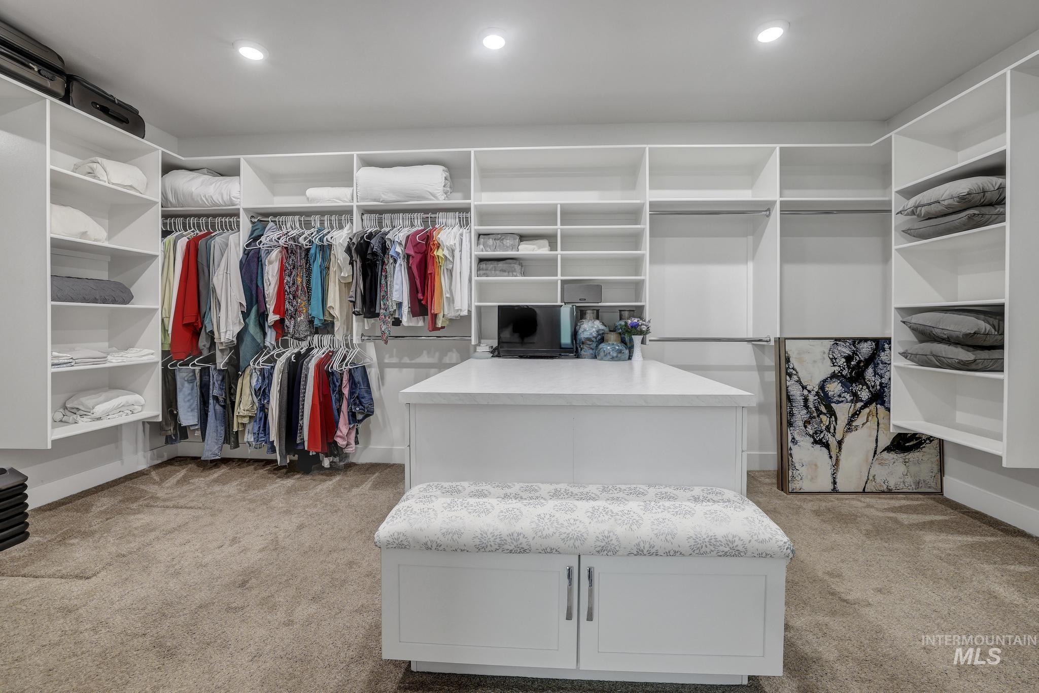 1937 Tamarack Loop Twin Falls, ID 83301 - Photo 36 of 50 Walk-in closet featuring extensive built-in shelving, multiple hanging rods, recessed lighting, a central island, and carpet flooring