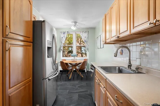 a kitchen with stainless steel appliances granite countertop a refrigerator and a sink