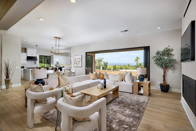 a living room with furniture a large window and a dining table