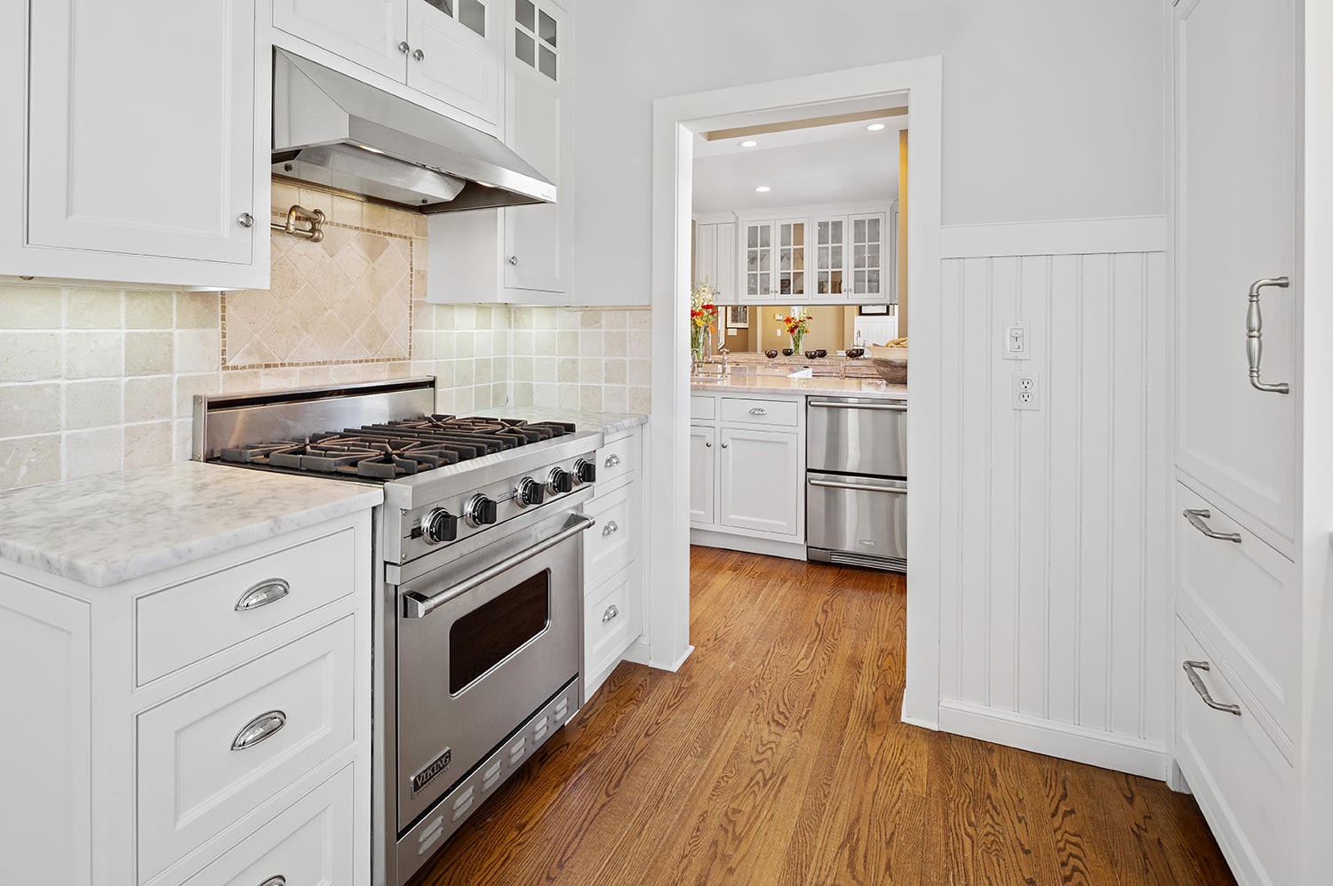 33 Old Farm Road Darien, CT 06820 - Photo 12 of 28 a kitchen with stainless steel appliances white cabinets and a wooden floor