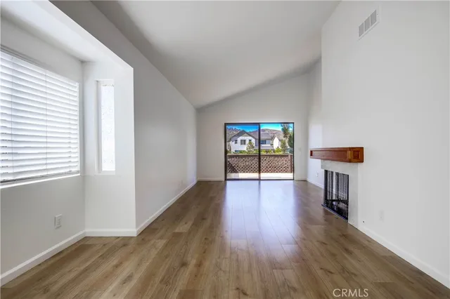 a view of a big room with wooden floor and windows