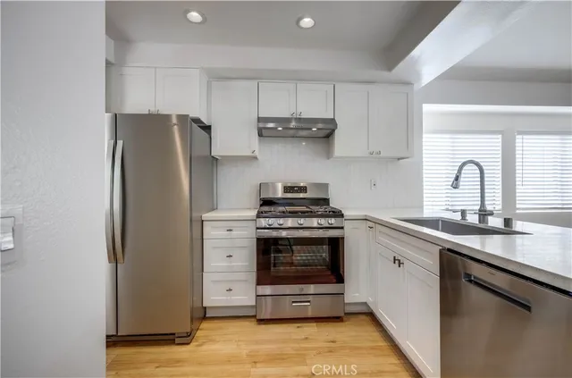 a kitchen with stainless steel appliances a stove a sink and a refrigerator