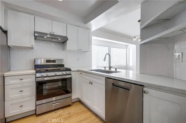 a kitchen with stainless steel appliances granite countertop a stove and a sink
