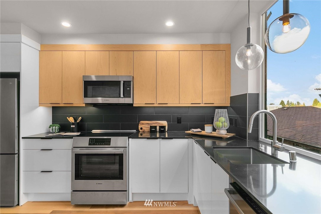 5200 Renton Avenue South Seattle, WA 98118 - Photo 10 of 21 a kitchen with stainless steel appliances granite countertop a sink stove and microwave