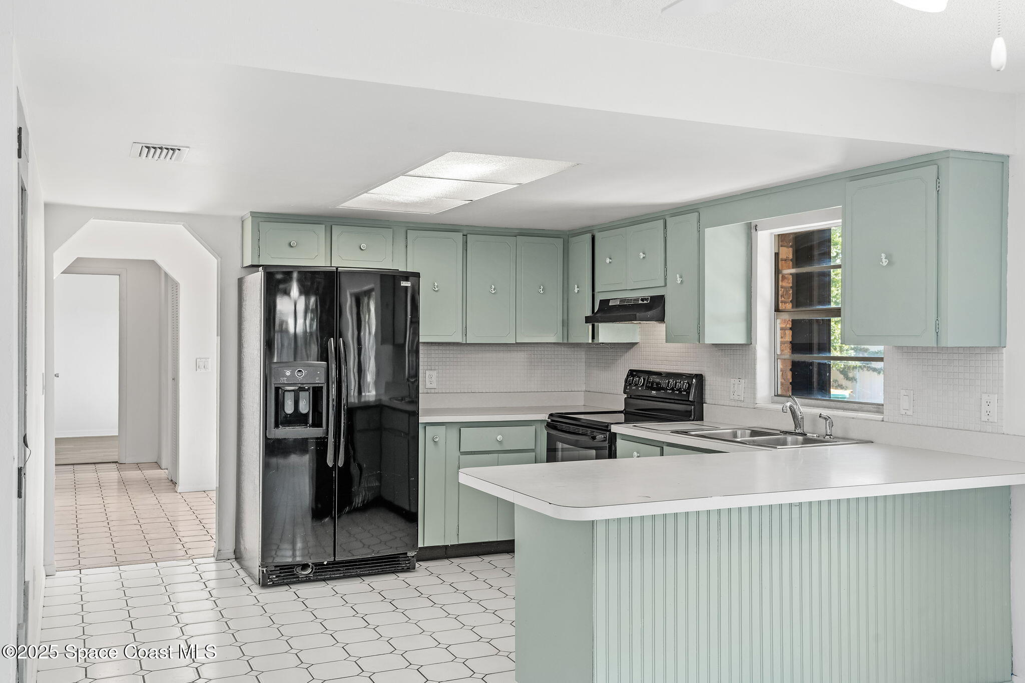2361 Colony Drive Melbourne, FL 32935 - Photo 25 of 40 a kitchen with stainless steel appliances a refrigerator sink and cabinets