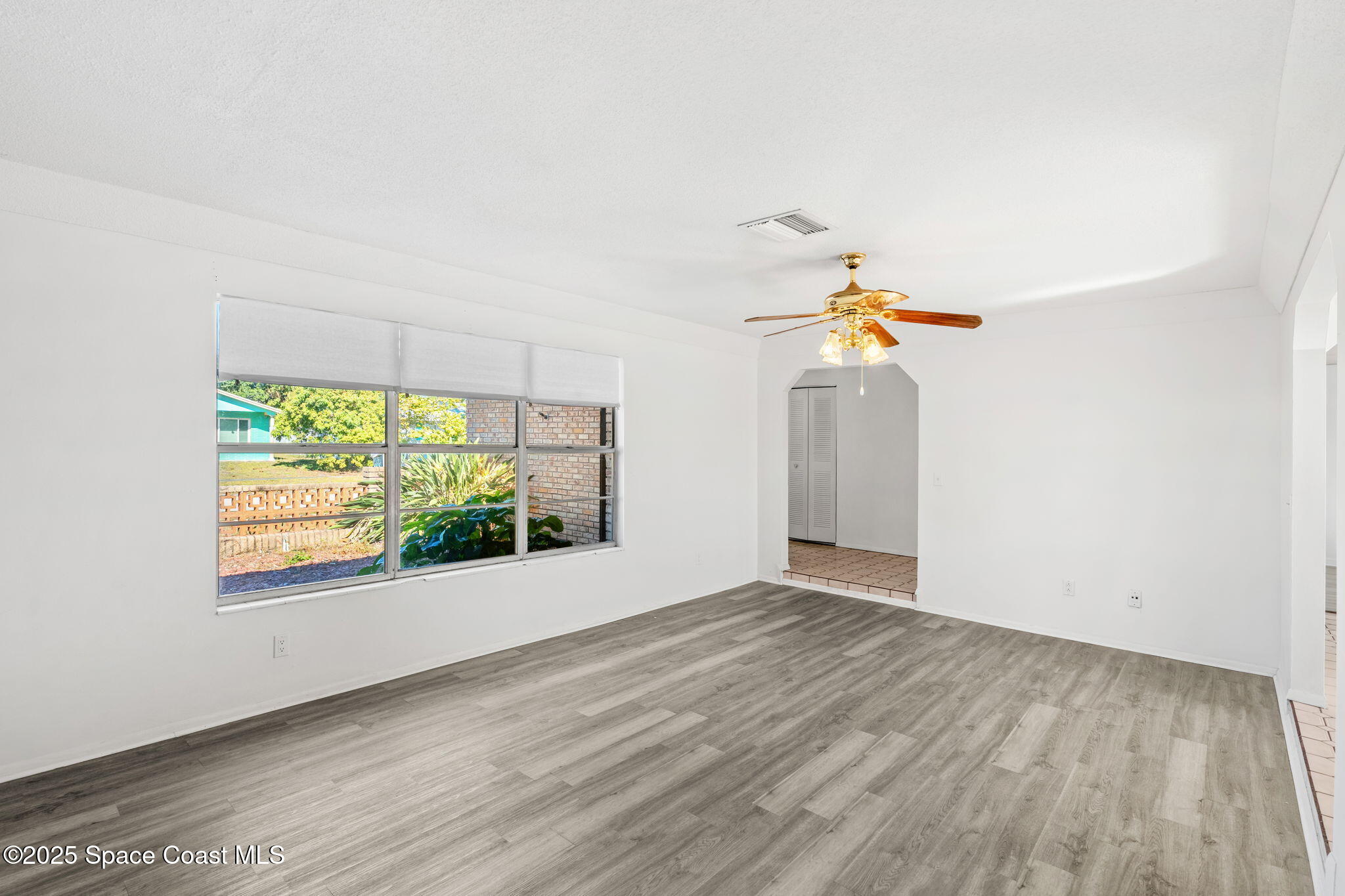 2361 Colony Drive Melbourne, FL 32935 - Photo 8 of 40 an empty room with windows and fan