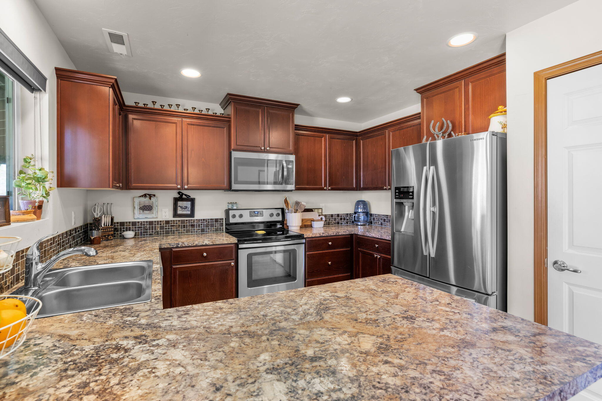 63639 Gentry Loop Bend, OR 97701 - Photo 13 of 40 a kitchen with granite countertop a refrigerator stove top oven and sink