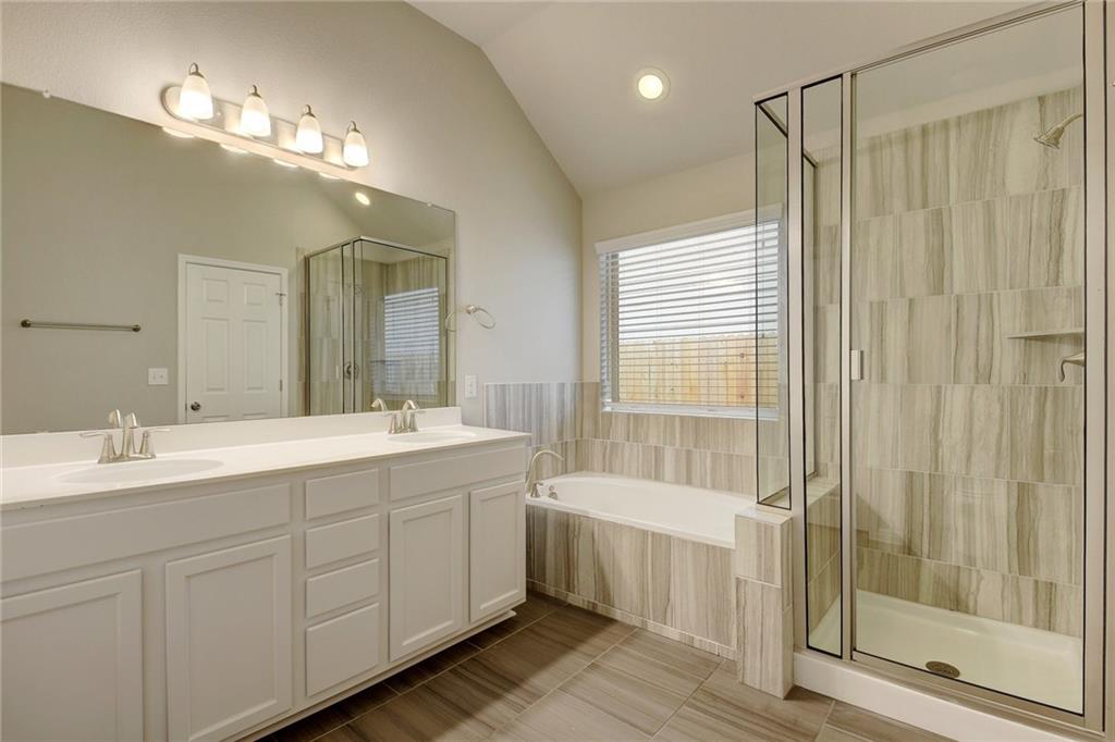13216 Mariscan Street Manchaca, TX 78652 - Photo 12 of 28 Bathroom with a garden tub, double vanity, a stall shower, lofted ceiling, and recessed lighting