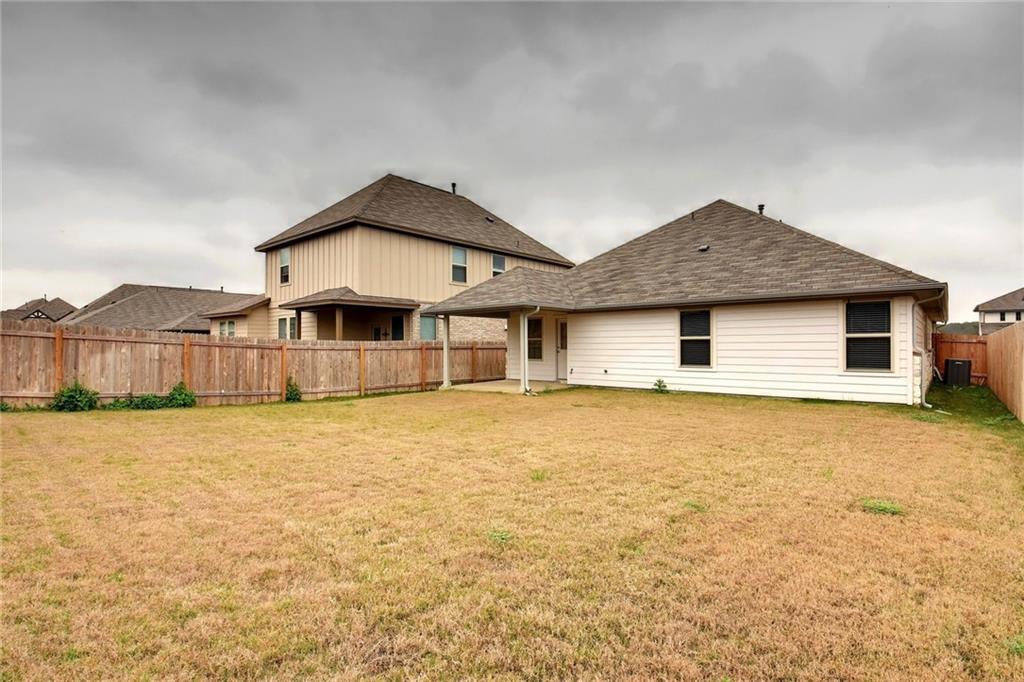 13216 Mariscan Street Manchaca, TX 78652 - Photo 18 of 28 Back of house featuring a fenced backyard, a patio area, and roof with shingles