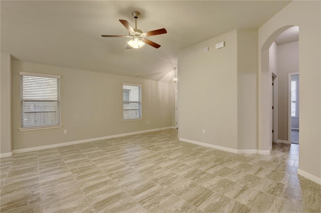 13216 Mariscan Street Manchaca, TX 78652 - Photo 3 of 28 Unfurnished room featuring a ceiling fan, arched walkways, plenty of natural light, and vaulted ceiling