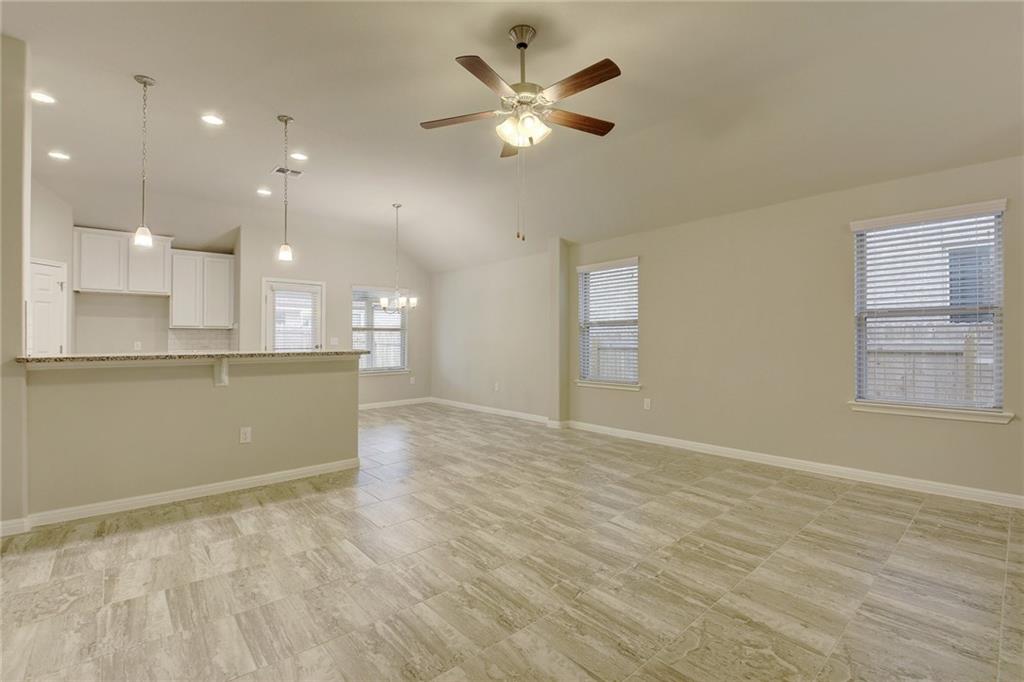 13216 Mariscan Street Manchaca, TX 78652 - Photo 4 of 28 Unfurnished living room with ceiling fan, suspended lighting, and vaulted ceiling