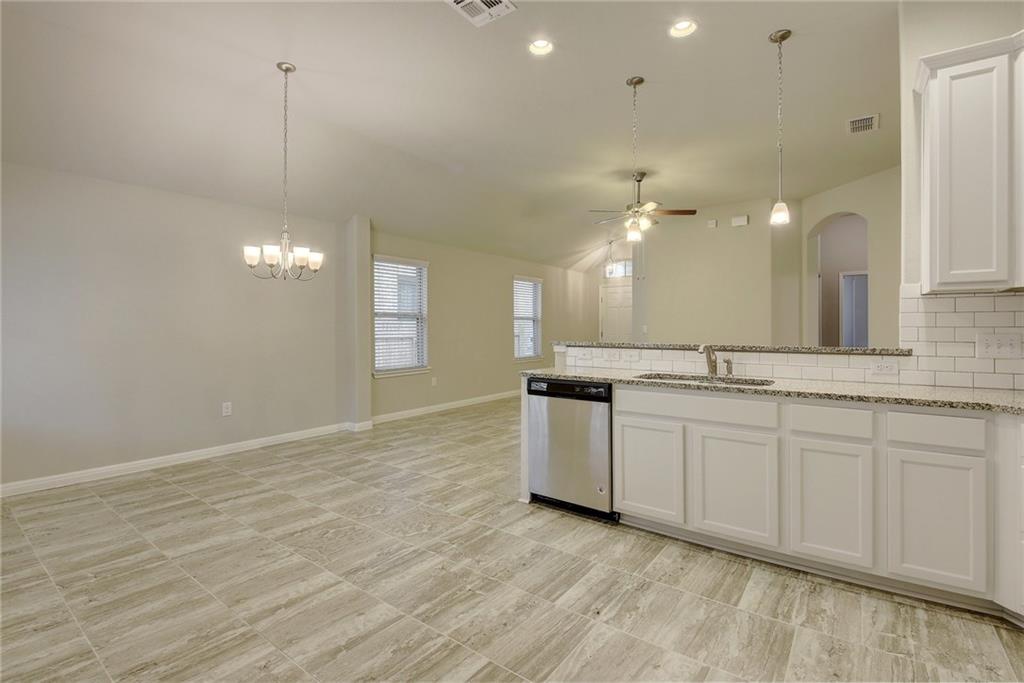 13216 Mariscan Street Manchaca, TX 78652 - Photo 28 of 28 Kitchen featuring a ceiling fan, white cabinets, stainless steel dishwasher, open floor plan, and a peninsula