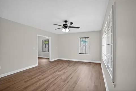an empty room with wooden floor and windows