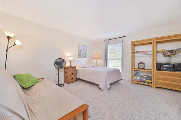 a spacious bedroom with a bed and a lamp