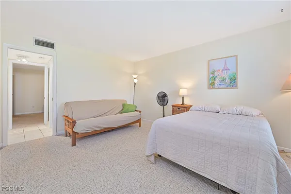 a spacious bedroom with a bed a table and large windows