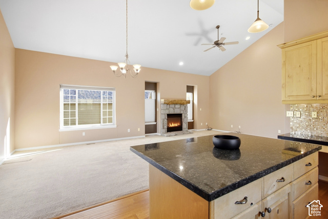 7396 Brook Hollow Loop Road Park City, UT 84098 - Photo 12 of 60 Kitchen island with dark countertop, light wood cabinetry, and a mosaic tile backsplash