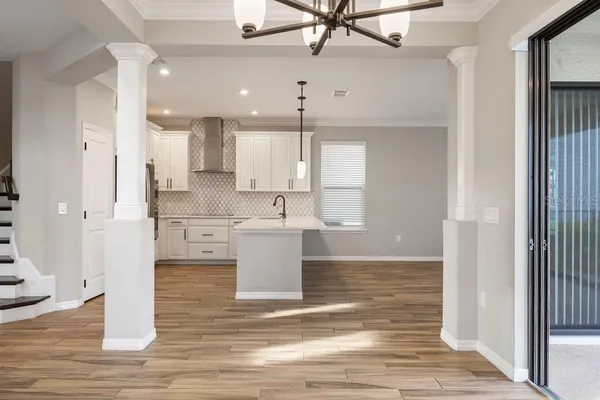 a view of a kitchen with wooden floor and a ceiling fan