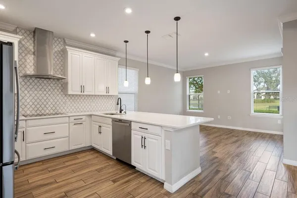 a view of a kitchen with wooden floor and windows