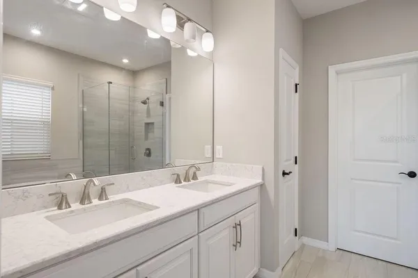 a spacious bathroom with a tub sink and mirror