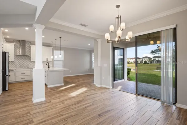 a view of a kitchen with kitchen island stainless steel appliances wooden floor and window