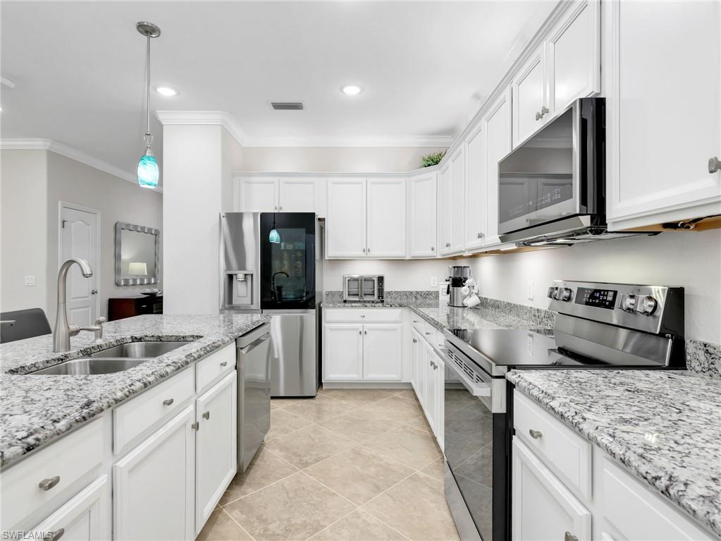 4383 Bismark Way Naples, FL 34119 - Photo 5 of 49 Kitchen with Sparkling New LG Stainless Steel Appliances, White Shaker Cabinetry, Under & Above Counter Lighting, Granite Counters, Pendant Lighting, & Crown Molding