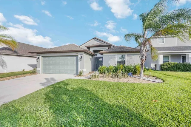a front view of a house with a yard and garage