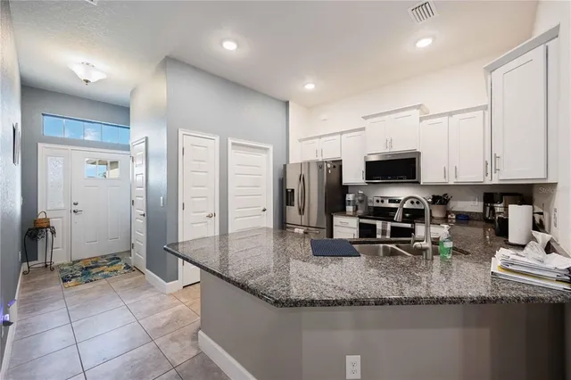 a kitchen with stainless steel appliances granite countertop a sink a stove and cabinets