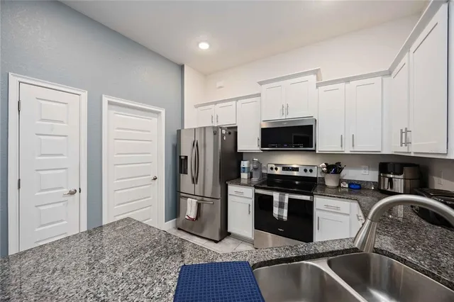 a kitchen with stainless steel appliances granite countertop a refrigerator and a sink