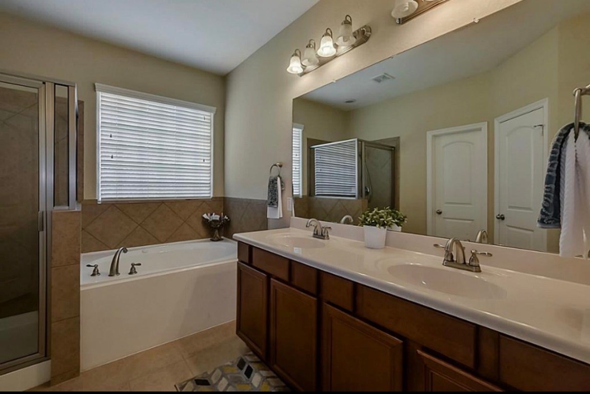 16710 Dover Mills Drive Spring, TX 77379 - Photo 12 of 15 a bathroom with a tub double sink and mirror