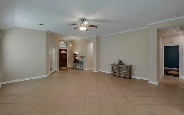 a view of an empty room with a chandelier fan